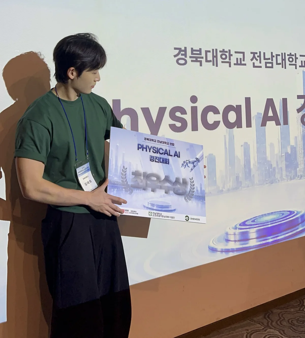 Physical AI 경진대회 시상 현장. 무대 앞에서 상패를 들고 선 모습.